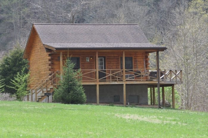 An exterior view of a log cabin in West Virginia with outdoor deck.