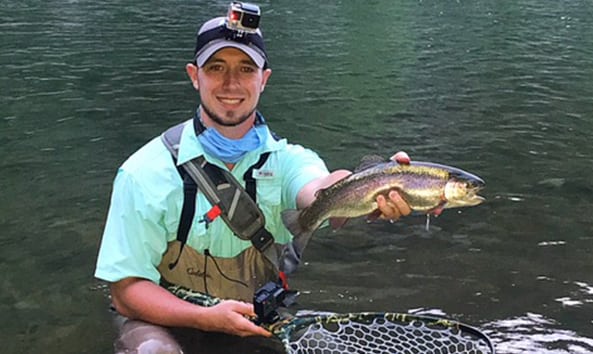 angler holding a fish and fishing net