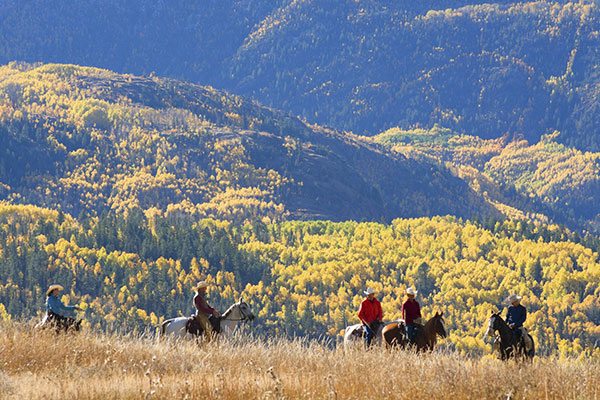 A group of people horseback riding along the West Virginia mountains