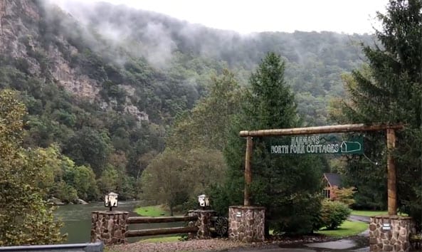 entrance to harman's luxury log cabins with a misty mountain top in the background